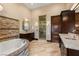 Spa-like bathroom featuring a soaking tub, glass-enclosed shower, and dual vanities with stone countertops at 5764 Aspen Falls Cir, Las Vegas, NV 89149