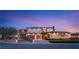 Elegant stucco home with a three-car garage and manicured landscaping at sunset at 5764 Aspen Falls Cir, Las Vegas, NV 89149