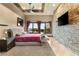 Luxurious main bedroom boasting stone accent wall, tray ceilings, and backyard pool views at 5764 Aspen Falls Cir, Las Vegas, NV 89149