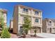 Three-story home featuring a two-car garage, desert landscaping, and a red tile roof at 6074 Gordon Creek Ave, Las Vegas, NV 89139