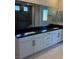 Elegant bathroom featuring white cabinetry, black countertop, and a large mirror at 7142 Twilight Rider Ct, Las Vegas, NV 89118