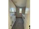 Well-lit laundry room with white cabinets, dark hardware, sink, and gray tile flooring at 7142 Twilight Rider Ct, Las Vegas, NV 89118
