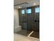 Modern walk-in shower boasting a glass enclosure, dark tile walls, and a built-in bench at 7142 Twilight Rider Ct, Las Vegas, NV 89118