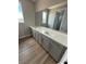 Large bathroom vanity with double sinks, quartz countertop, gray cabinets and wood-look tile at 7199 Twilight Rider Ct, Las Vegas, NV 89118