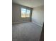An empty bedroom is filled with neutral carpet and a window overlooking a scenic outdoor view at 7199 Twilight Rider Ct, Las Vegas, NV 89118