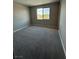 A gray carpeted bedroom features a window overlooking scenic outdoor views at 7199 Twilight Rider Ct, Las Vegas, NV 89118