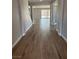 Hallway with stylish wood-look tiling leading to the sunlit backyard and featuring access to the staircase at 7199 Twilight Rider Ct, Las Vegas, NV 89118