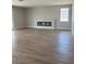 Open living room space with light hard surface flooring, a long fireplace and a large window at 7199 Twilight Rider Ct, Las Vegas, NV 89118
