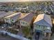 An aerial view of a residential neighborhood with modern homes, brick paved driveways, and landscaped yards at 7629 Rosebark Cliffs St, North Las Vegas, NV 89084