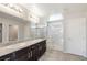 Bathroom featuring double sinks with granite vanity, tile floors and a glass enclosed shower at 7629 Rosebark Cliffs St, North Las Vegas, NV 89084