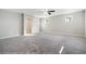 Spacious bedroom with soft gray carpet, fan and multiple windows for natural light at 7629 Rosebark Cliffs St, North Las Vegas, NV 89084