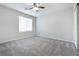 A bedroom with neutral walls, carpet, a window, and a ceiling fan at 7629 Rosebark Cliffs St, North Las Vegas, NV 89084