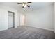 A spacious bedroom with carpet flooring, closet, and a ceiling fan at 7629 Rosebark Cliffs St, North Las Vegas, NV 89084