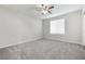 A bedroom featuring gray carpet, a window, and a ceiling fan at 7629 Rosebark Cliffs St, North Las Vegas, NV 89084