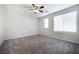 A bedroom featuring gray carpet, a window, and a ceiling fan at 7629 Rosebark Cliffs St, North Las Vegas, NV 89084