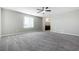 Large bedroom with gray carpet, ceiling fan, and view of the bathroom at 7629 Rosebark Cliffs St, North Las Vegas, NV 89084