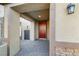 Covered entryway featuring a brick-paved walkway, a red door, and a modern exterior light fixture at 7629 Rosebark Cliffs St, North Las Vegas, NV 89084