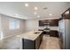 Bright kitchen featuring granite countertops, stainless steel appliances, and dark wood cabinetry at 7629 Rosebark Cliffs St, North Las Vegas, NV 89084