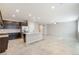 Open floor plan combining the kitchen and living area, filled with natural light and tile flooring at 7629 Rosebark Cliffs St, North Las Vegas, NV 89084