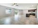 Spacious living room featuring tile floors, bright natural light, and an open layout to the kitchen at 7629 Rosebark Cliffs St, North Las Vegas, NV 89084