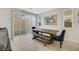 Modern dining area with a rustic wooden table, stylish blue chairs, and sliding doors to outdoor space at 787 Cottonwood Hill Pl, Henderson, NV 89011