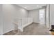 Upstairs hallway with neutral carpet, white railing, and doorway to a bedroom at 787 Cottonwood Hill Pl, Henderson, NV 89011