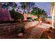 Backyard featuring manicured landscaping, paver patio and walkway, mature bushes, and exterior brick wall at 8433 Sea Glen Dr, Las Vegas, NV 89128
