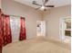 Well-lit bedroom with neutral carpet, ceiling fan, and decorative curtains at 8433 Sea Glen Dr, Las Vegas, NV 89128
