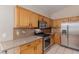 Updated kitchen featuring stainless steel appliances, wooden cabinets, and tiled backsplash at 8433 Sea Glen Dr, Las Vegas, NV 89128
