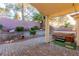Covered patio with a hot tub, brick pavers, and lush landscaping, perfect for relaxation at 8433 Sea Glen Dr, Las Vegas, NV 89128