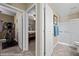 Hallway view of a room with an exercise machine and a bedroom with a ceiling fan at 870 Santa Maria Way, Mesquite, NV 89027