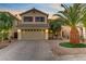 Charming two-story home featuring a well-manicured front yard with a paver driveway and mature landscaping at 10899 Royal Highlands St, Las Vegas, NV 89141