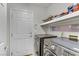 Functional laundry room with modern washer and dryer and storage shelving at 10899 Royal Highlands St, Las Vegas, NV 89141