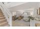 Bright living room with a staircase, neutral-toned furniture, tile floors, and plantation shutters for privacy at 10899 Royal Highlands St, Las Vegas, NV 89141