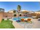 Outdoor pool area featuring lounge chairs, patio umbrella, manicured lawn, and palm tree at 10899 Royal Highlands St, Las Vegas, NV 89141