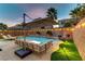 Evening view of pool area with lounge seating, string lights, and mature landscaping at 10899 Royal Highlands St, Las Vegas, NV 89141