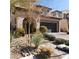 Two-story home with desert landscaping, a dark gray garage door, and a paved driveway at 10976 Bluebell Basin Rd, Las Vegas, NV 89179