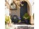 Charming front porch with a dark blue front door, plants, and a wooden chair at 10976 Bluebell Basin Rd, Las Vegas, NV 89179