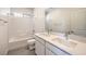 Bathroom features a double sink vanity with stone counter and tub with white tiled wall at 11576 Ashy Storm Ave, Las Vegas, NV 89138