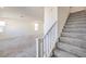 Bright living room featuring neutral carpet, fresh white paint, and a staircase leading to the upper level at 11576 Ashy Storm Ave, Las Vegas, NV 89138