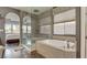 This main bathroom features a glass enclosed shower and tub with natural light and access to the main bedroom at 12118 La Carta Ct, Las Vegas, NV 89138