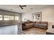 Living room features a large brown couch, hardwood floors, white walls, and plenty of light from the window at 12118 La Carta Ct, Las Vegas, NV 89138