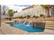 Inviting pool and spa featuring a rock waterfall, mature landscaping, and privacy wall at 12118 La Carta Ct, Las Vegas, NV 89138