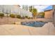 Backyard with a pool, waterfall features, mature landscaping, and privacy wall at 12118 La Carta Ct, Las Vegas, NV 89138