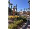 Elegant community entrance with a decorative fountain, flowers, and palm trees on a clear day at 1525 Spiced Wine Ave # 12103, Henderson, NV 89074