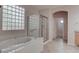 Bright bathroom featuring a tub, glass block window, and a glass-enclosed shower at 1534 Waterford Falls Ave, Las Vegas, NV 89123