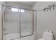 Bright bathroom featuring a shower over tub with glass door and a toilet at 1534 Waterford Falls Ave, Las Vegas, NV 89123