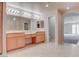 A well-lit bathroom featuring tile floors, light-colored cabinets, and and sinks at 1534 Waterford Falls Ave, Las Vegas, NV 89123