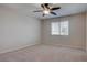 A bright, empty bedroom featuring neutral carpet and a ceiling fan with an attached light fixture at 1534 Waterford Falls Ave, Las Vegas, NV 89123