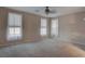 A bright, empty bedroom featuring neutral carpet and large windows with neutral colored blinds at 1534 Waterford Falls Ave, Las Vegas, NV 89123